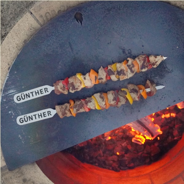 Grillspieße mit Wunschname auf Grillplatte der Feuerstelle
