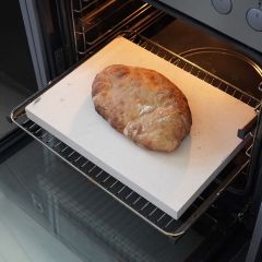 Brotbackstein 40 x 30 x 3 cm aus Schamotte von Schamotte-Shop.de mit selbst gebackenem Brot auf Rost