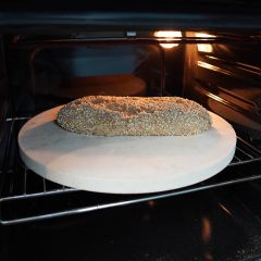 Haselnussbrot auf rundem Brotbackstein Ø 49 x 2 cm aus Keramik von Schamotte-Shop.de im Backofen