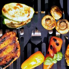 Grillgut liegt um Flammen-Ausschnitt im eckigen Grillrost auf Maß