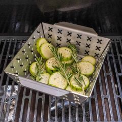 Kleiner Grillkorb aus Edelstahl mit Zucchini und Rosmarin auf Grill