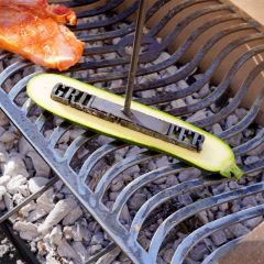 Grillstempel "Grillmeister" wird auf halbe Zucchini auf dem Grill gedrückt