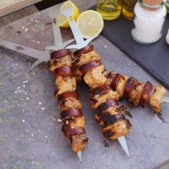 Kleine Grillspieße im Schwert Design aus Edelstahl mit gegrillter Chorizo und Hähnchenfleisch auf Tisch