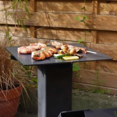 Massiver Grillstahl auf Maß mit Grillgut auf Raketenofen