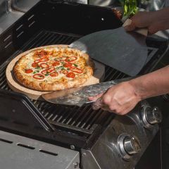 Pizza Paddles aus Edelstahl von Schamotte-Shop.de werden unter Pizza geschoben