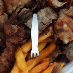 Pommespieker aus Edelstahl steckt in Pommes neben Kebab