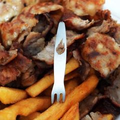 Pommespieker mit Flamme steckt in knuspriger Pommes auf Grillteller