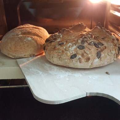 Fertig gebackene Brot von Brotbackstein holen