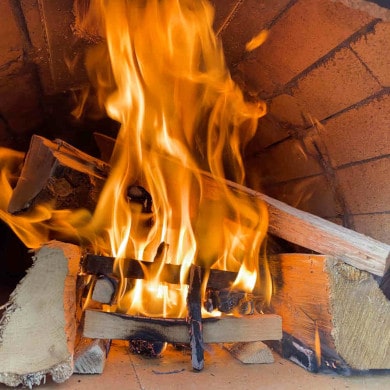 Pizzaofen anfeuern - Holz nachlegen