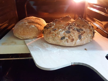 Fertig gebackenes Brot vom Brotbackstein holen