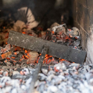 Mit dem Schürhaken im Pizzaofen arbeiten