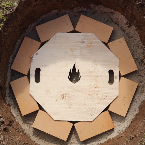 Schablone liegt auf der 1. Stein-Reihe der Feuerstelle