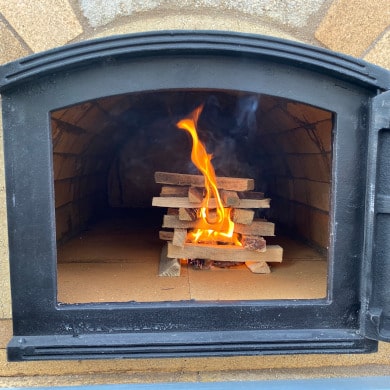 Pizzaofen anfeuern: Holz nachlegen