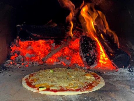 Die Pizza bäckt im angefeuerten Ofen