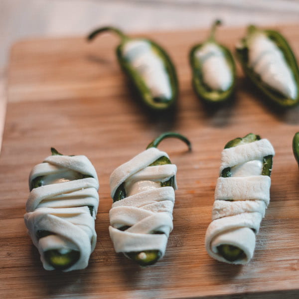 Gefüllte Jalapenos mit Blätterteig zu Mumien wickeln