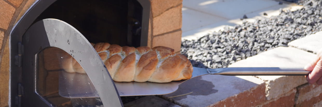 Hefezopf wird aus dem Pizzaofen geholt