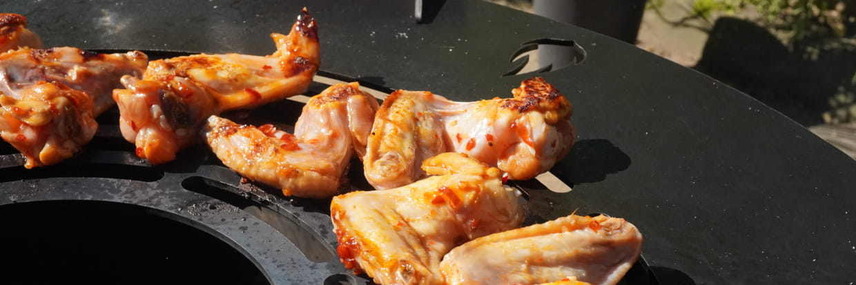 Chicken Wings grillen auf Feuerplatte