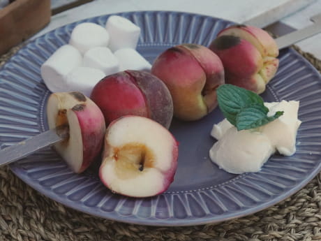 Teller mit flambierten Pfirsisch auf Grillspieß