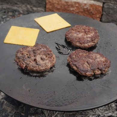 Burger Patties und Scheibenkäse auf Feuerplatte