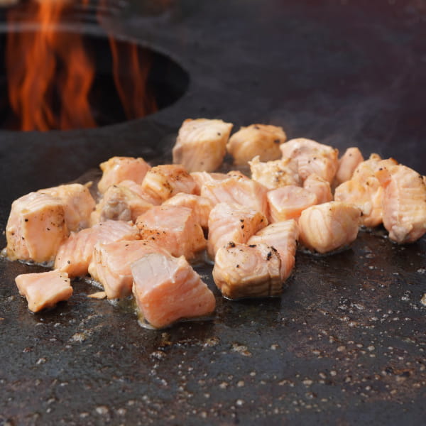 Lachswürfel auf der Feuerplatte braten