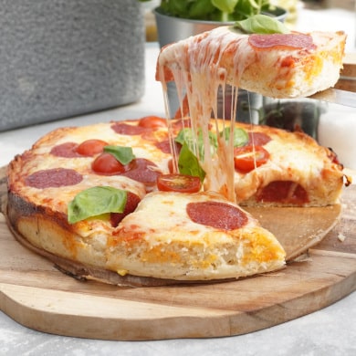 Stück einer gebackenen American Pan Pizza mit geschmolzenem Käse