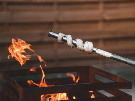 Herzhaftes Stockbrot über der Feuerschale grillen