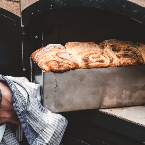 Kastenform mit Apfel-Zimt-Brot wird aus Pizzaofen geholt