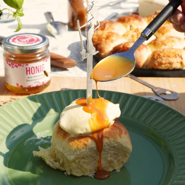 Honig über gefüllte Buchteln mit Eis am Spieß geben