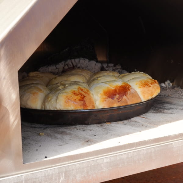 Gebackene Buchteln mit Apfelfüllung auf Blech im Pizzaofen