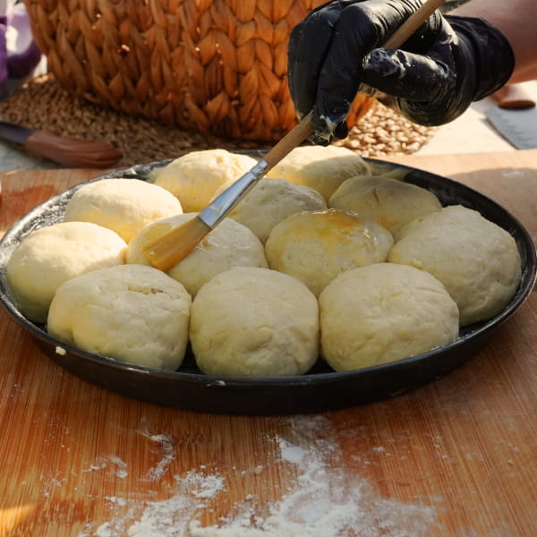 Apfelbuchteln auf Blech mit Honig bestreichen