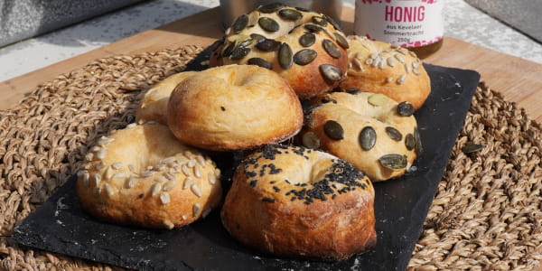 Bagels mit Saaten auf Steinbrett angerichtet