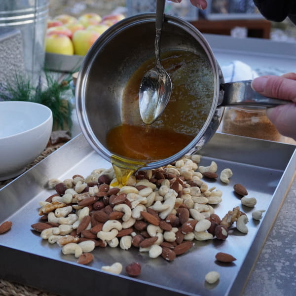 Nüsse auf einem Backblech mit Butter Honig Mischung ummanteln