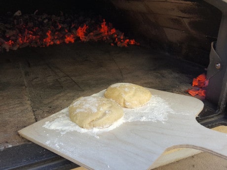 Kartoffellbrötchen-Teiglinge in den Pizzaofen legen