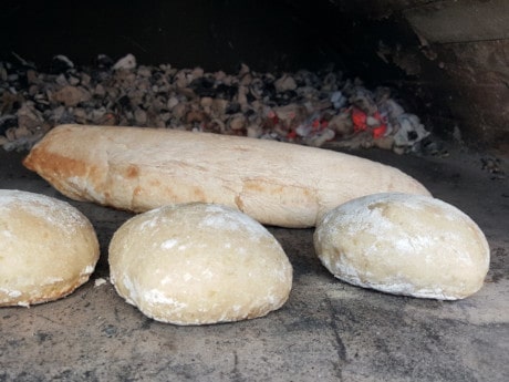 Baguette-Teigling in den Pizzaofen legen