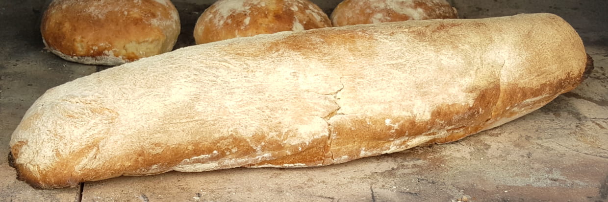 Fertig gebackenes französisches Baguette mit Brötchen im Pizzaofen